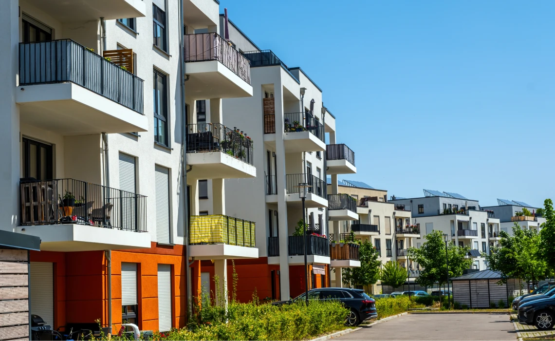 Modern apartment buildings with balconies and cars.