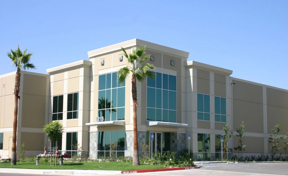 Modern office building with palm trees outside.