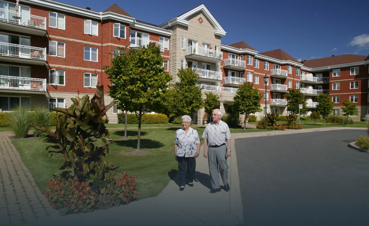 Elderly couple walking outside residential building.